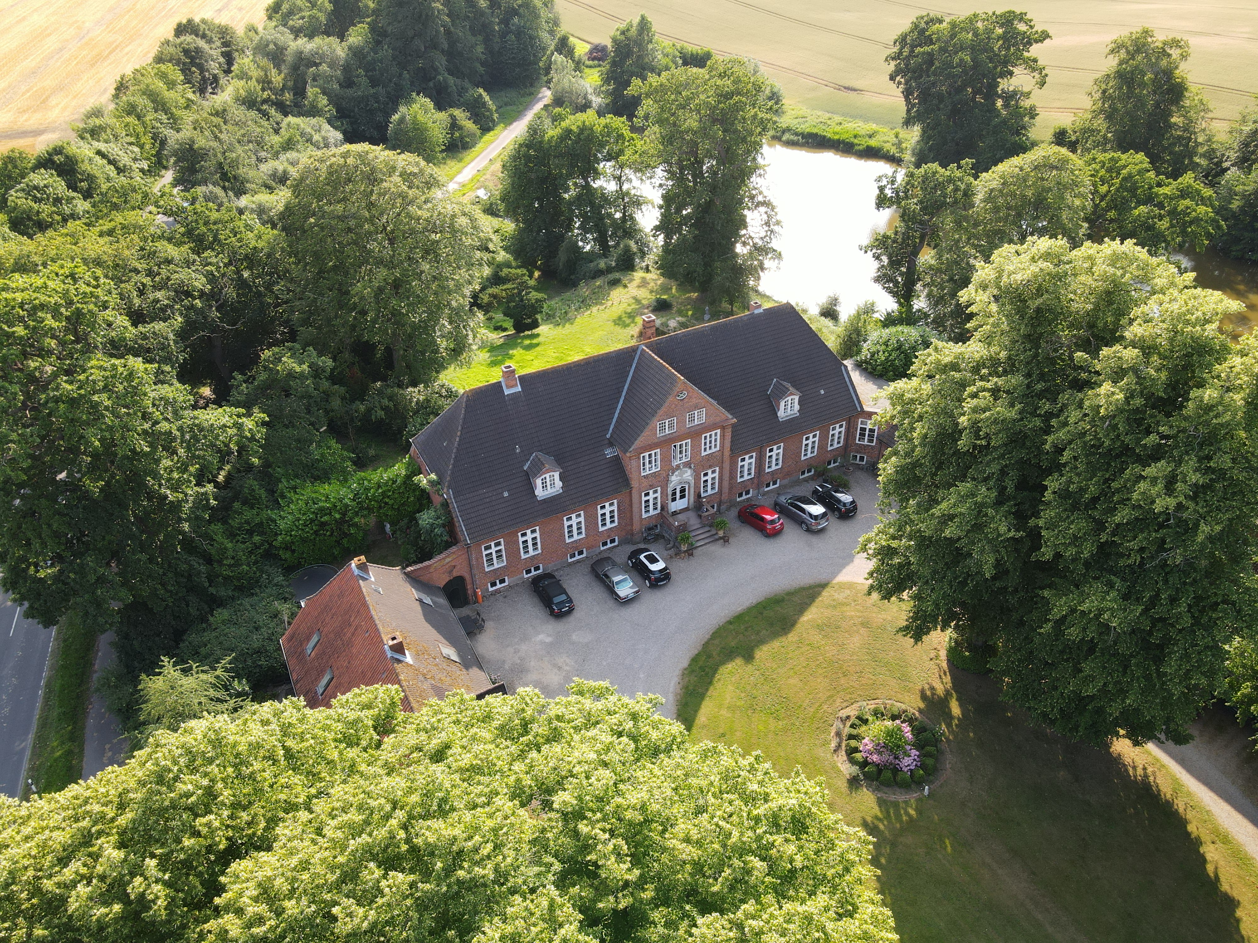 Picture of the house (Herrenhaus) in Eckhof. Also showing green nature, pond and fields around it.